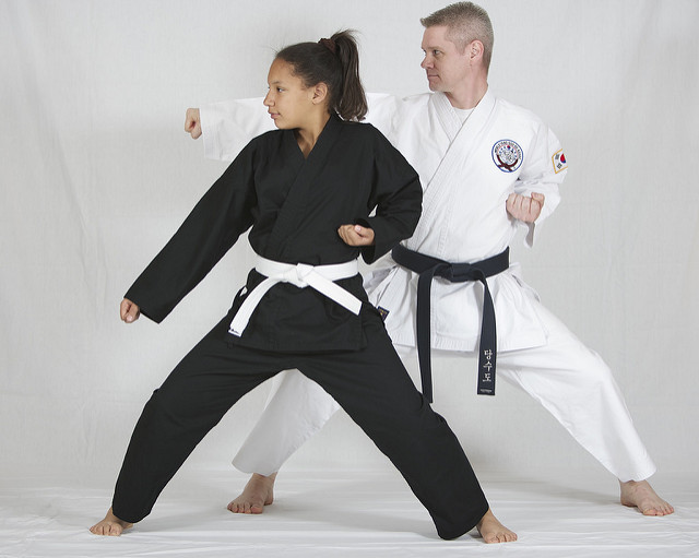 A black belt teaching a white belt